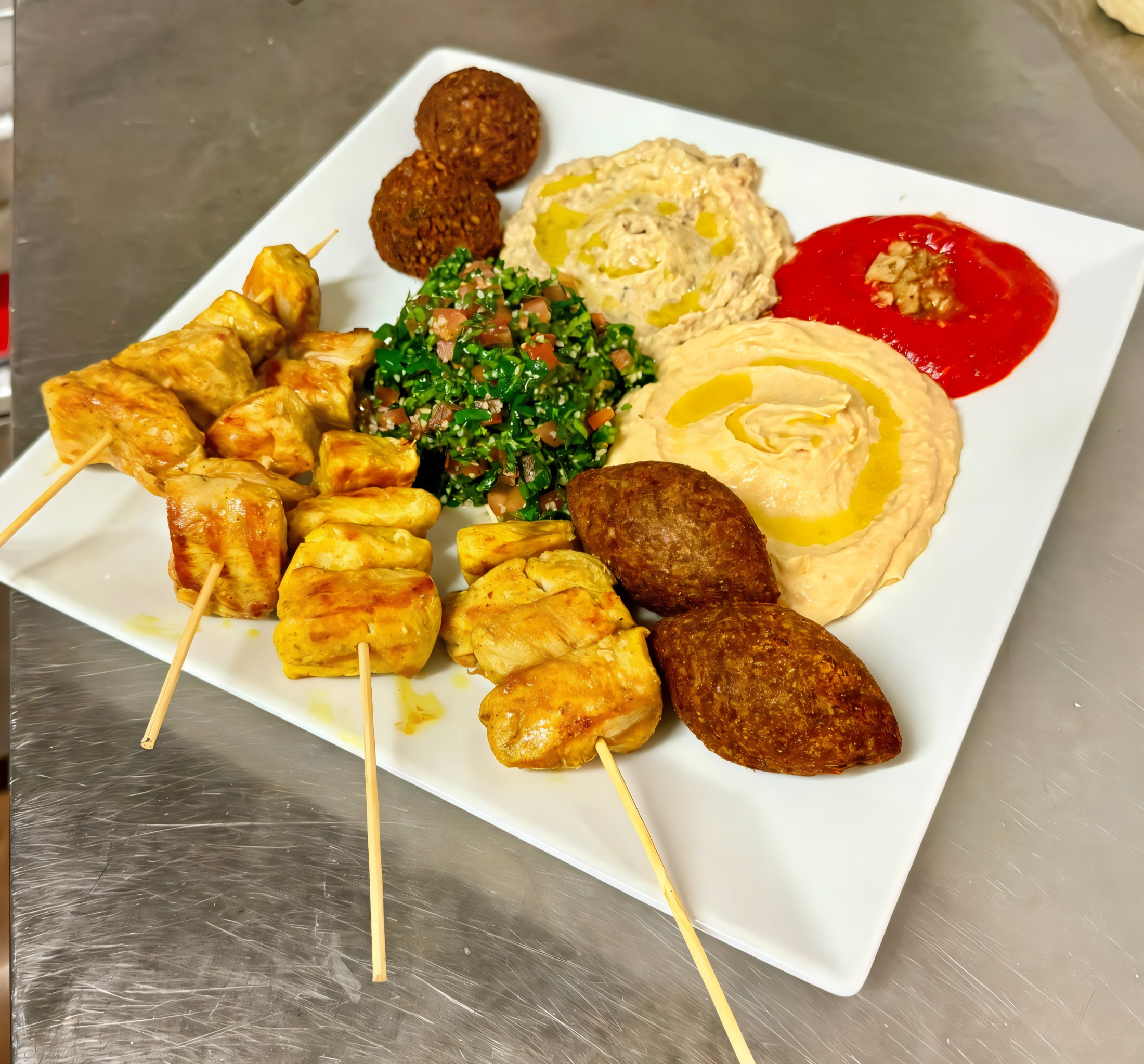 Plato para compartir con pinchos de pollo, kibbe, hummus y muhammara