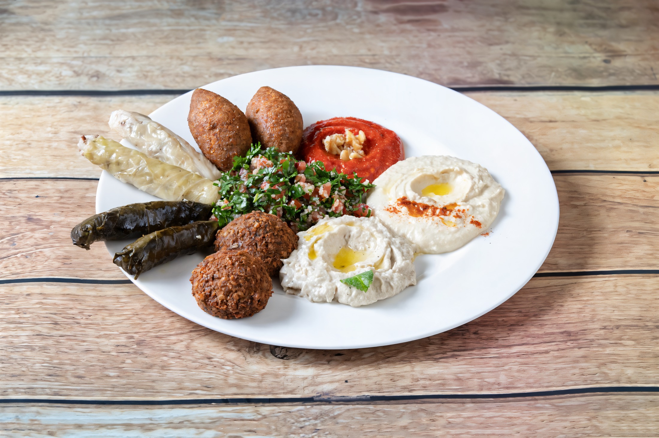 Mixed platter: hummus, mutabal, muhammara, falafel, kibbeh, tabbouleh and vine leaves