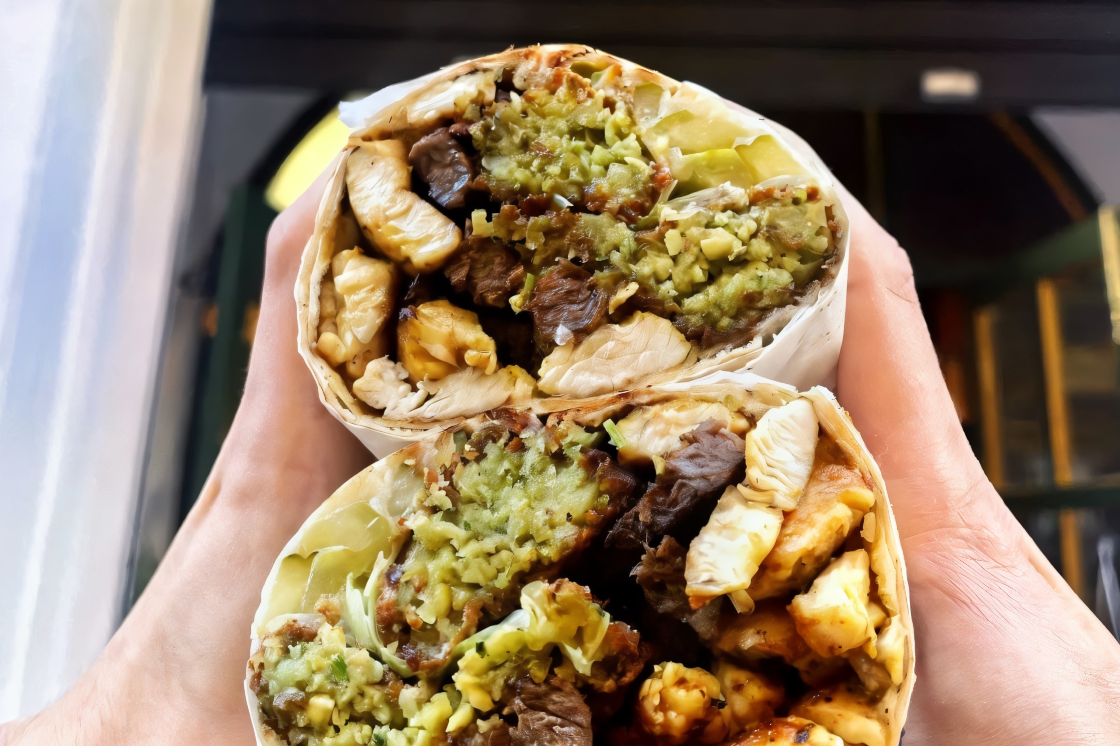 Two Hommus Falafel shawarmas cut open, with falafel, chicken and beef